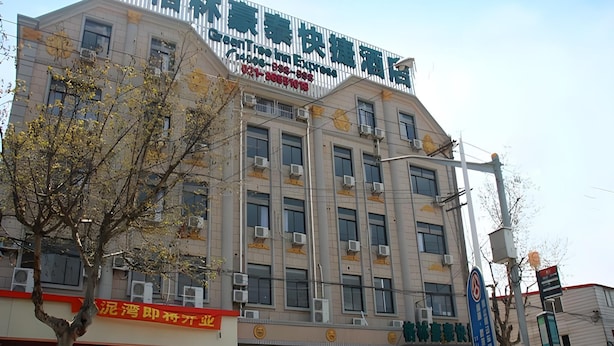 A multi-story hotel with a prominent sign at the top. - Greentree Inn Shanghai Luojing Express Hotel (Shanghai)