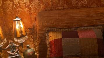 Een kamer met een bed, een lamp en een klein beeldje.