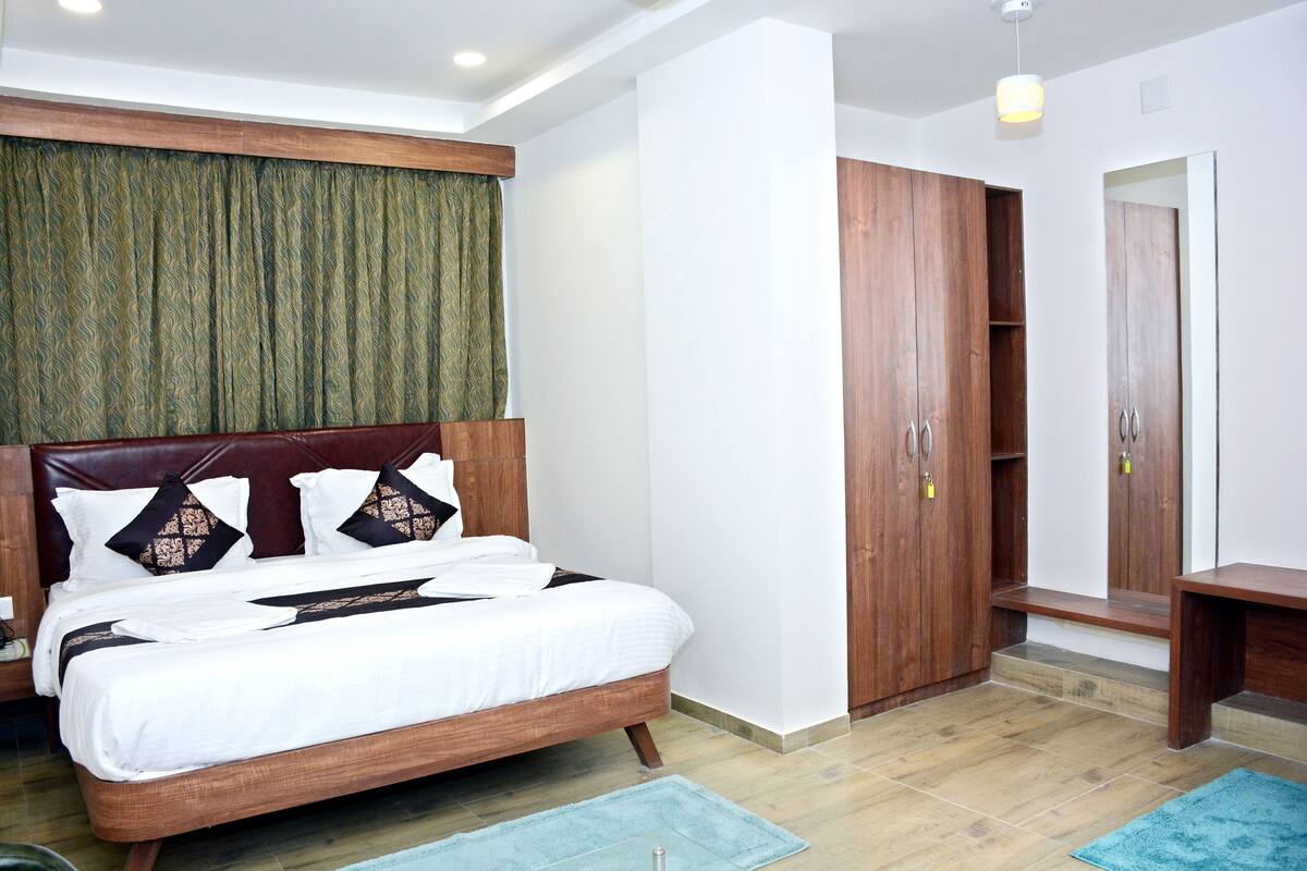 Un dormitorio con cama, armario de madera y espejo.