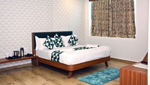 A neatly arranged bedroom with a bed, bedside tables, a desk, and a window with curtains.
