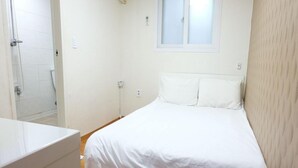 A bedroom with a bed, a window, and a shower area. - Oh My Inn (Seoul)