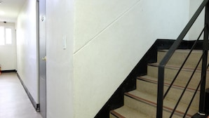 A staircase with black railings and beige carpeted steps. - Oh My Inn (Seoul)