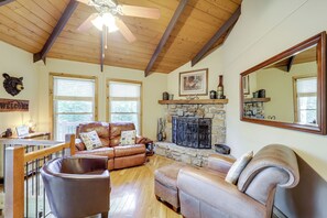 A cozy living room with leather sofas, a stone fireplace, and a large mirror. - 2 Mi to Skiing! Wooded Beech Mtn Retreat w/ Decks (Beech Mountain)