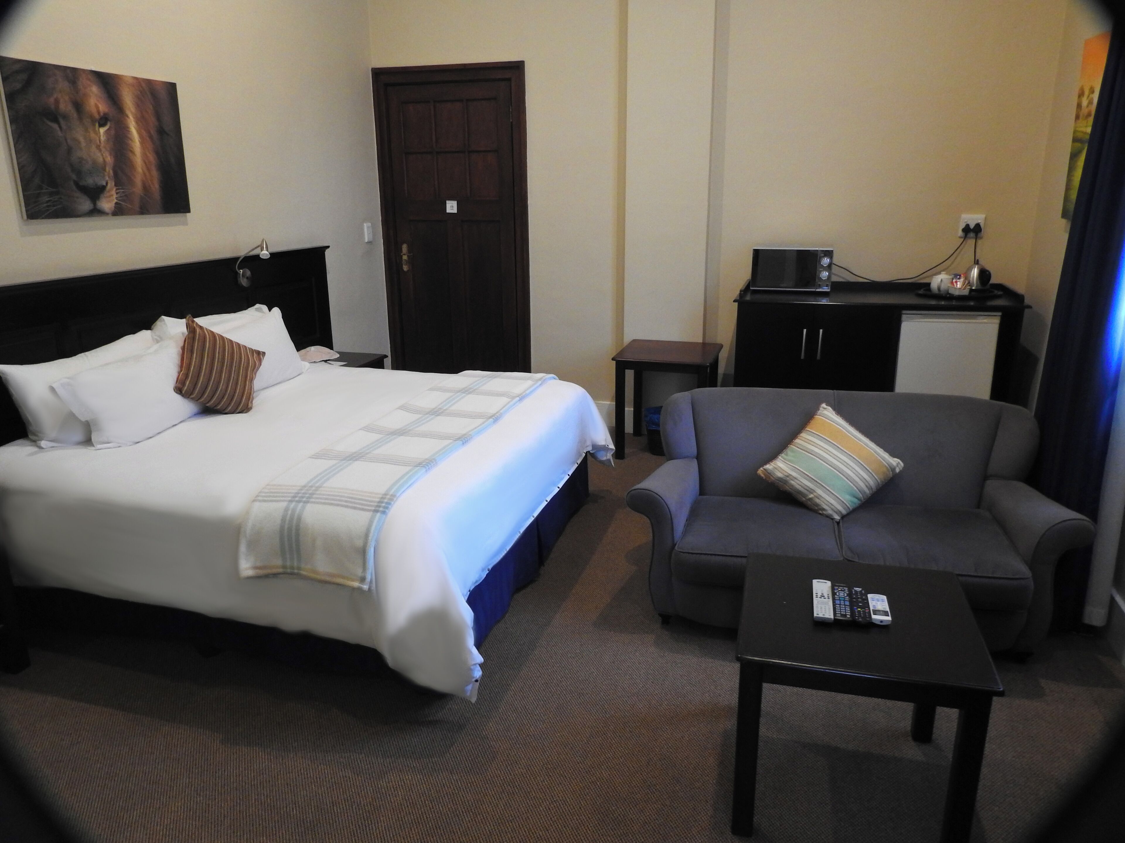 Habitación de hotel con una cama, un sofá, un escritorio y una mesita.
