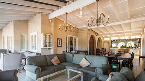 A spacious living area with a large sectional sofa, a glass coffee table, and a dining table with chairs. - Albion Manor (Durban)