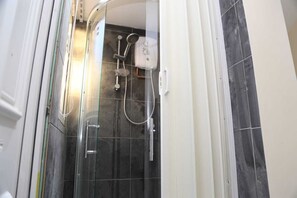 A glass-enclosed shower with a handheld showerhead and a wall-mounted control panel. - Budget 4-bedrooms In Thamesmead (London)