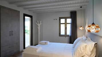 Ein Schlafzimmer mit Bett, Kleiderschrank, Fenster und Tür.