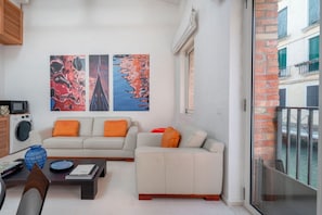A modern living room with a sofa, coffee table, and artwork on the wall.
