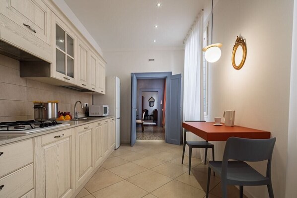 A kitchen with cabinets, a stove, and a dining area with a table and chairs.