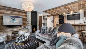 A cozy living room with a fireplace, a sofa, and a television.