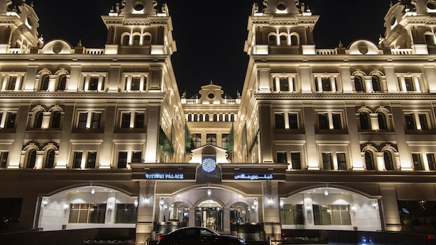 Un hotel imponente con fachada simétrica, amplias ventanas y una entrada destacada.