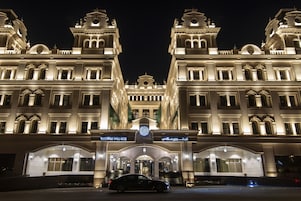A grand hotel with a symmetrical facade, large windows, and a prominent entrance.