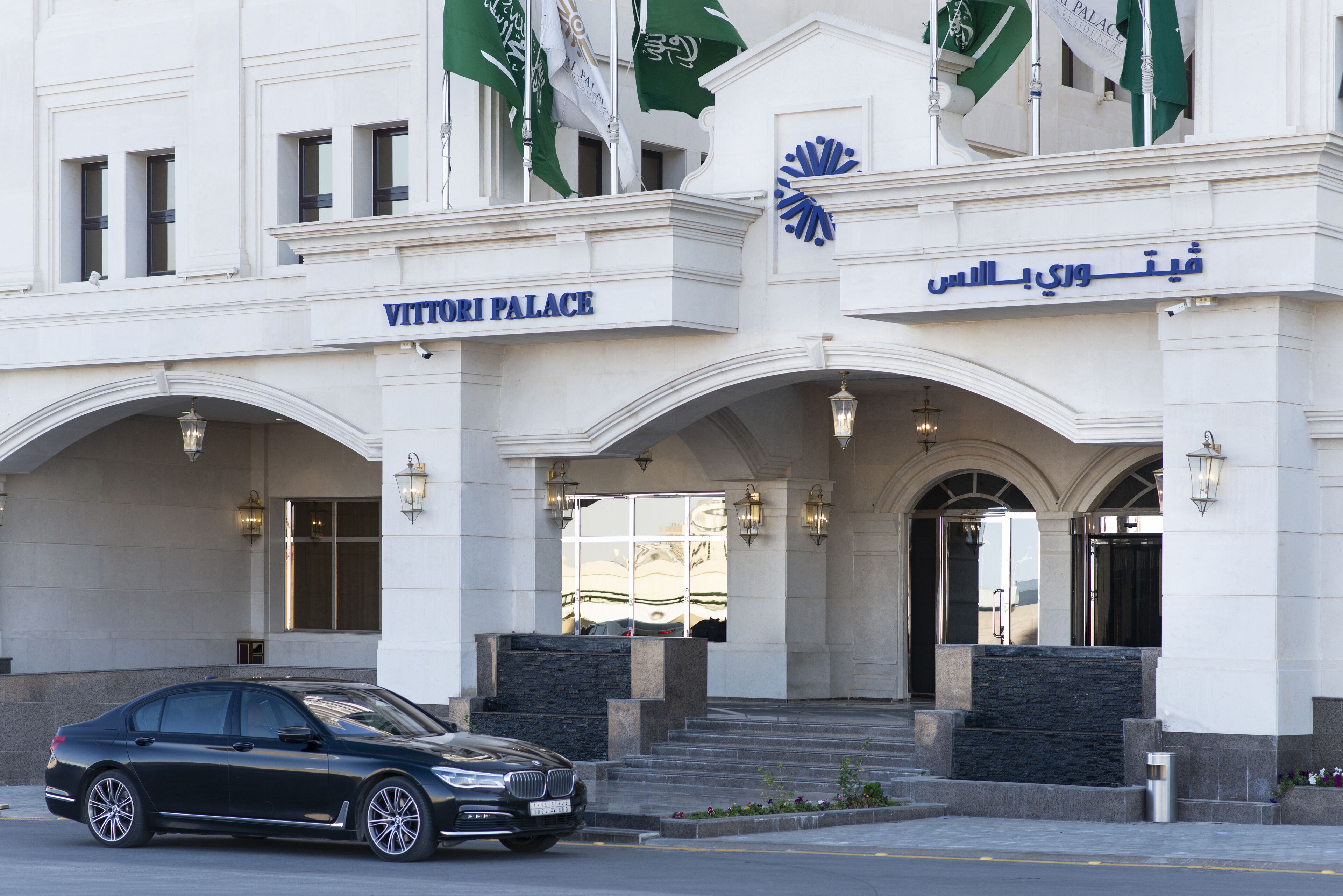 The entrance to Vittori Palace with a black car parked in front.