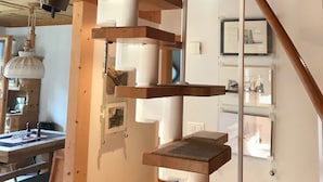 A room with a wooden staircase, a workbench, and a hanging light fixture.