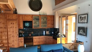 A cozy living room with a blue sofa and wooden cabinets.