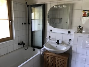 Tina con regadera, bidet, toallas, papel de baño