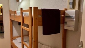 A bunk bed room with a wooden frame, a white mattress, and a dark towel hanging on the top bunk. - Apartment Montgenèvre 4 people, parking, ski-in/ski-out (Montgenèvre)