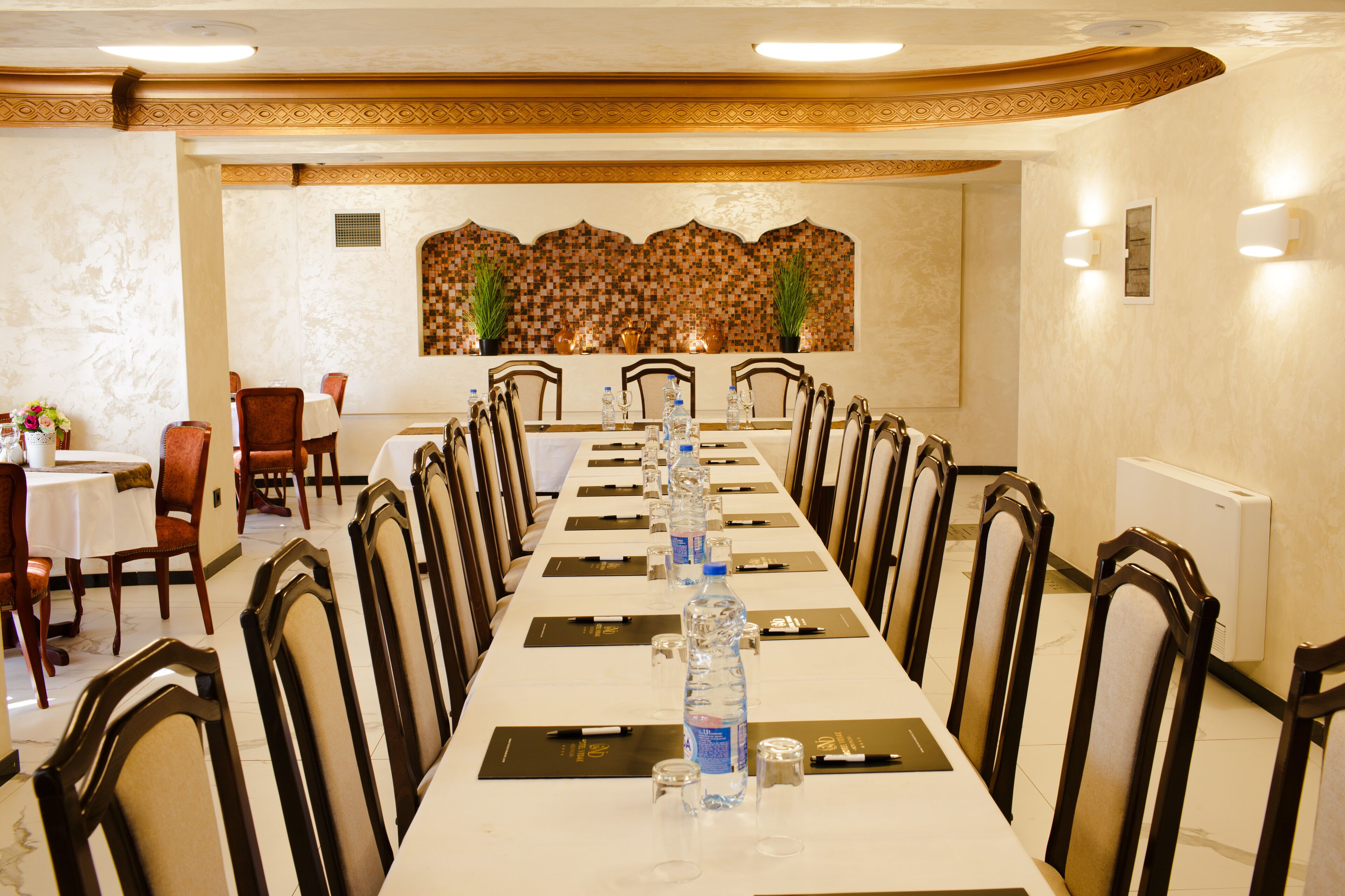A conference room with a long table, chairs, water bottles, and nameplates.