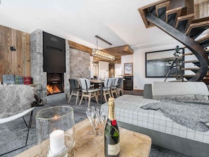 Una sala de estar moderna con chimenea, un comedor y una zona de estar acogedora.