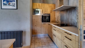 A kitchen with wooden cabinets, a built-in oven, a microwave, and a stone backsplash.
