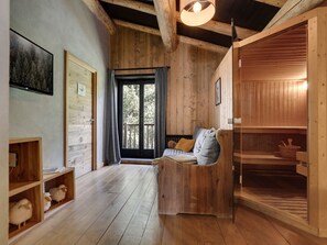 Un intérieur en bois avec un canapé, une étagère en bois ornée de figurines de moutons, une porte et une fenêtre avec des rideaux.