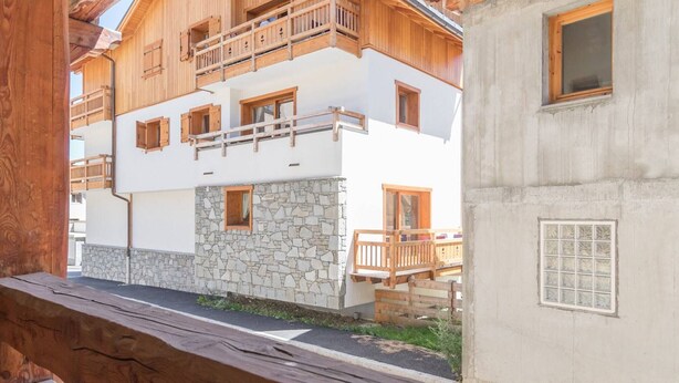 Un edificio de varios pisos con balcones de madera y paredes de piedra.