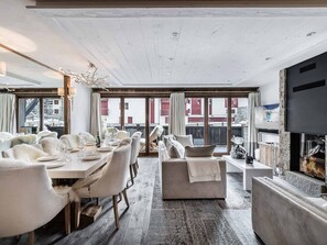 Relax in a spacious room with a dining area, comfortable seating, and a fireplace.