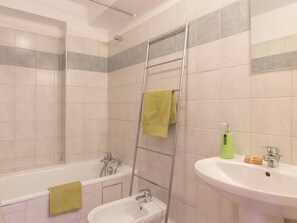 Ein Badezimmer mit einer Badewanne, einem Waschbecken und einer Dusche.