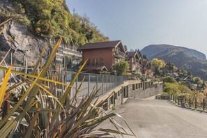 Een woonwijk op een helling met huizen, een verharde weg en een metalen brug.