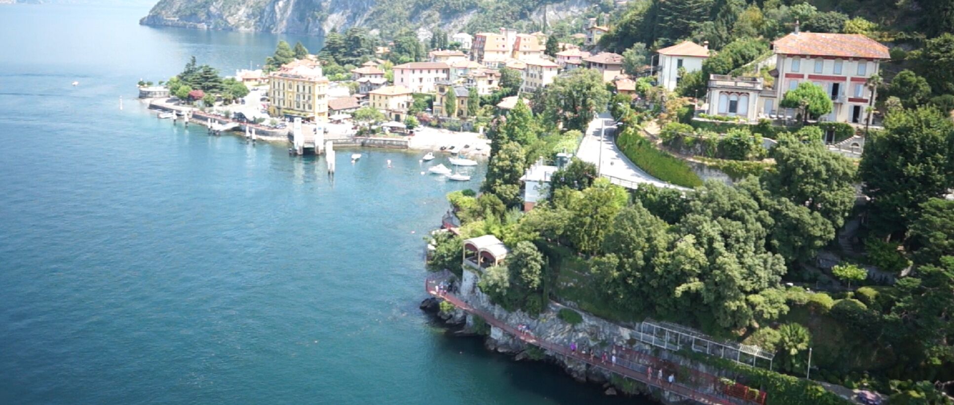 Une ville côtière avec des bâtiments qui bordent le littoral, un pont reliant la terre à l’eau et une vue dégagée sur la mer.