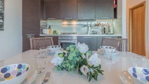 Mesa de comedor dispuesta con fuentes, vasos y un centro de mesa floral.