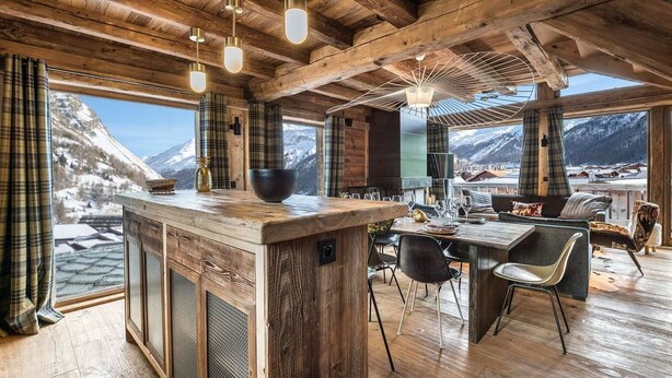 A rustic wooden interior with a bar area, dining space, and large windows offering mountain views. - Luxurious Chalet with Panoramic Views, Jacuzzi, Hammam, Near Slopes, Sleeps 10 (Val-d'Isère)