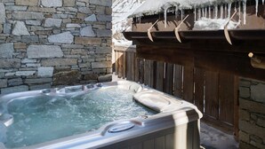A stone-walled hot tub with a wooden roof, set against a snowy mountain backdrop. - Luxurious Chalet with Panoramic Views, Jacuzzi, Hammam, Near Slopes, Sleeps 10 (Val-d'Isère)