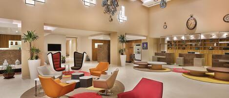 A spacious lobby with modern seating, a reception area, and a well-lit interior.