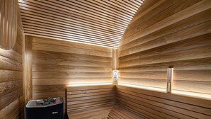 A sauna with wooden slats on the walls and ceiling, a bench, and a heater. - Authentic chalet with sauna and shuttle in Saint Martin (Saint-Martin-de-Belleville)