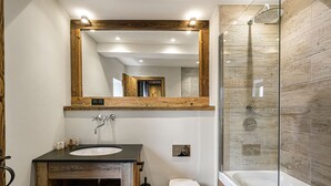A modern bathroom with a wooden vanity, a large mirror, a bathtub, and a shower. - Authentic chalet with sauna and shuttle in Saint Martin (Saint-Martin-de-Belleville)