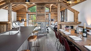 A spacious kitchen with a large island, wooden beams, and modern bar stools. - Authentic chalet with sauna and shuttle in Saint Martin (Saint-Martin-de-Belleville)