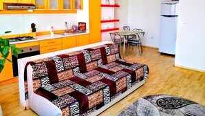 A compact living space with a kitchenette, a dining area, and a sofa.