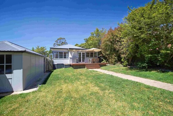 A residential property with a house, a covered porch, and a well-maintained lawn.