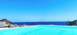 Piscine extérieure, parasols de plage, chaises longues