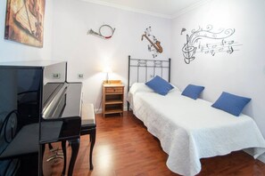 Ein Schlafzimmer mit Bett, Schreibtisch und einer Wand mit Noten und einem Saxophon.