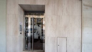 A building entrance with a glass door and a sign indicating a parking area. - El pentagrama de Cadiz (Cádiz)