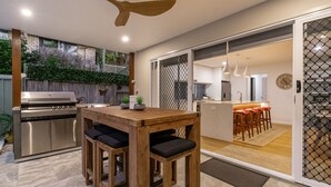 A modern kitchen with a built-in oven and a dining area with a wooden table and chairs.