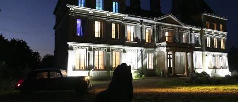 Un edificio grande y antiguo con numerosas ventanas y una entrada bien iluminada.