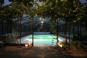 Piscina coberta com deck de madeira e velas.