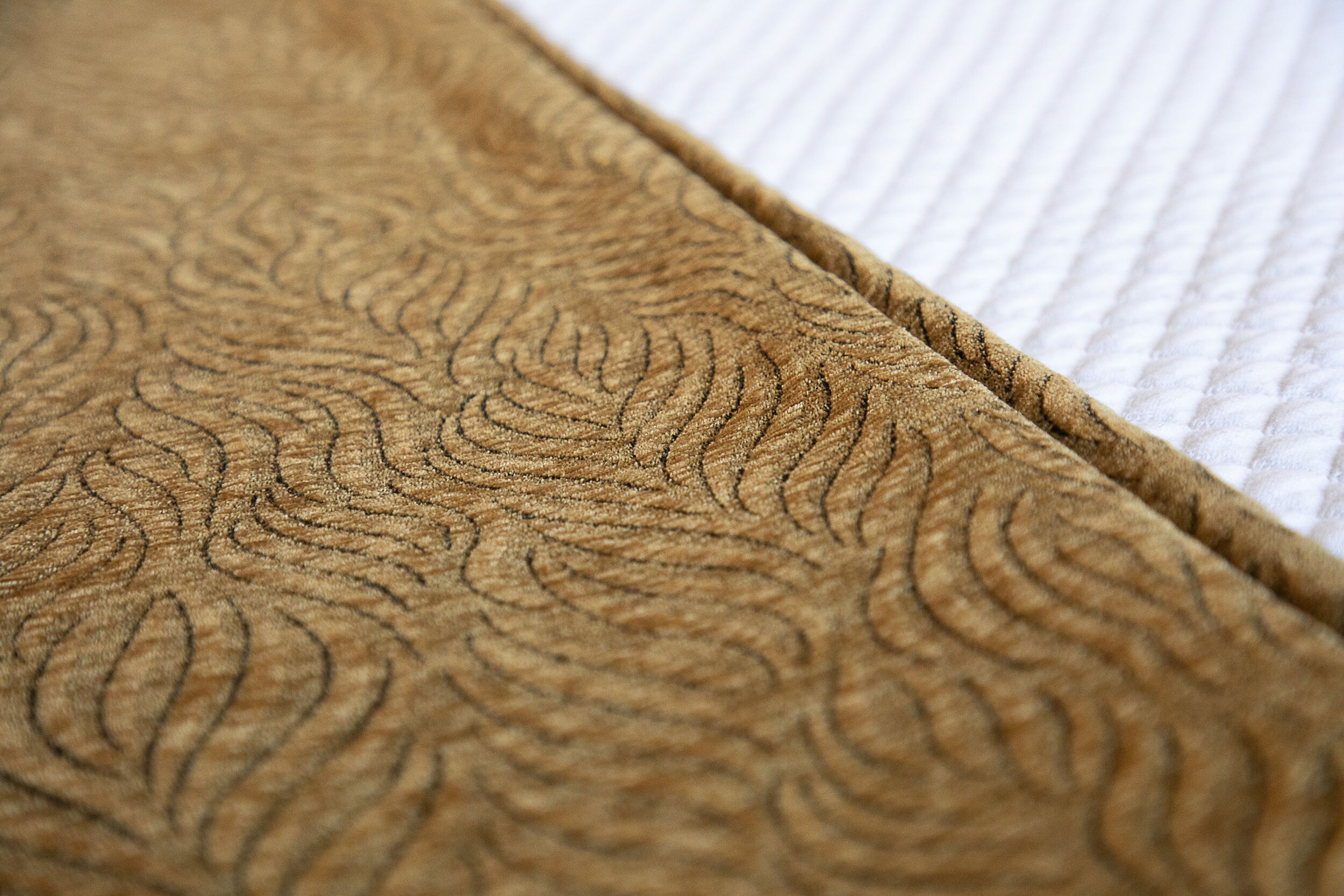 A close-up of a textured fabric with a leaf-like pattern.