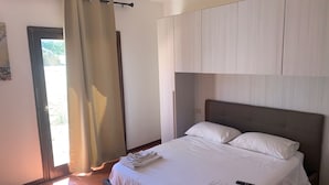 Une chambre d’hôtel avec un lit, une télécommande et une fenêtre avec des rideaux.