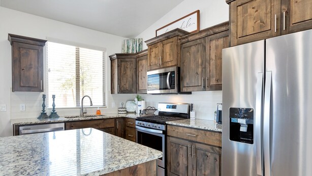 A modern kitchen with wooden cabinets, stainless steel appliances, and a granite countertop. - Rock Canyon Oasis 4 Bedroom Home by RedAwning (Washington)