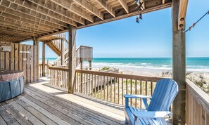 A wooden deck with a view of the ocean, a wooden staircase, and a blue Adirondack chair. - Stories By The Sea - 5 BR, 4.5 BA Oceanfront, Spectacular Views, Private Hot Tub (North Topsail Beach)