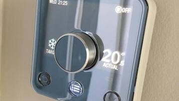 A thermostat with a digital display showing "Wed 21:25" and "OFF" status, a temperature setting of "20°C", and a "TARG" label.